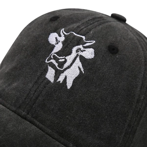 Close-up of white cow head embroidery on black washed cotton baseball cap texture