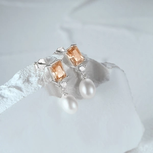 Macro detail of S925 silver earrings with champagne zircon and teardrop pearls