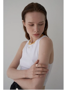 Model wearing minimalist daisy ring with layered freshwater pearl and yellow bead necklaces