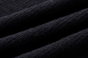 Close-up of soft navy knit fabric texture with fine stitching and fluffy material feel