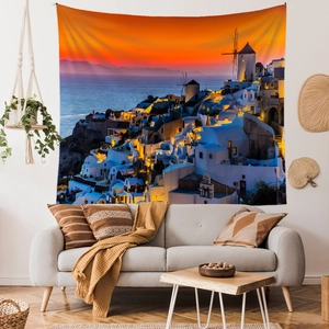 Santorini sunset wall tapestry hanging above a grey sofa in a cozy living room decor