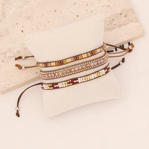 Detail of bohemian hand-woven seed bead bracelets on a white display pillow