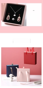 Detailed view of jewelry gift boxes with silk handles in pink, navy, and red colors
