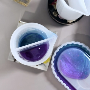 Dual-chamber silicone split cup for resin art with blue and purple glitter liquid