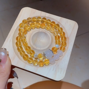 Detail of yellow chalcedony beaded bracelet with white jade bead and silver accents