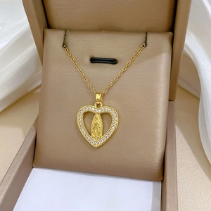 Close-up of gold heart pendant with Virgin Mary relief and pavé rhinestones