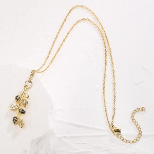 Elegant gold-plated leaf pendant necklace with zircon and black enamel on white background