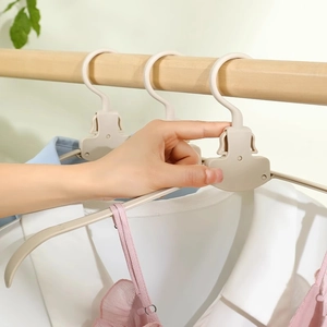 Foldable non-slip plastic travel clothes hanger with clips in beige and light brown finish