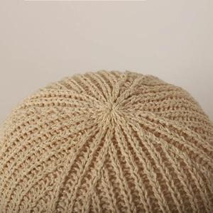 Detailed macro view of the seamless radial knit pattern on this beige sun hat crown