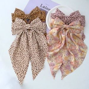 Detailed view of leopard print bow hair clips in multiple colors with silk streamers