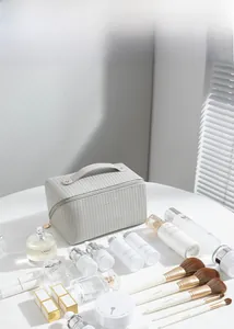 Detailed view of grey vertical stripe texture on a stylish makeup bag with gold zippers