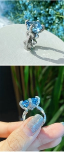 Macro detail of Asscher cut aquamarine ring with diamond-encrusted interlaced band