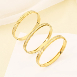 Three 18K gold plated stainless steel bangles with crystal inlay on geometric pedestals