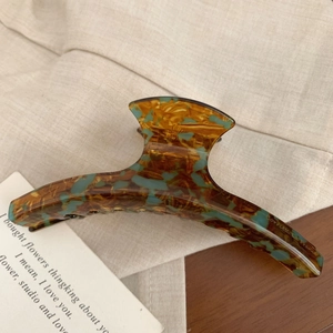 Détail d'une pince à cheveux française en acétate avec motif léopard ambre et vert