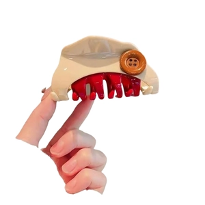 Beige triangle hair claw clip with brown button detail and red inner teeth for women
