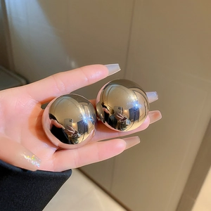 Macro shot of polished silver stripe earrings with a glossy mirror finish and chunky style