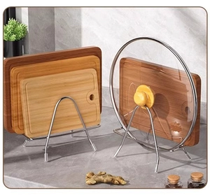 Kitchen organizer showing stainless steel rack holding cutting boards and glass lids