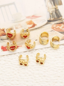Detail view of 18k gold plated heart ear cuffs with red enamel and Mama lettering