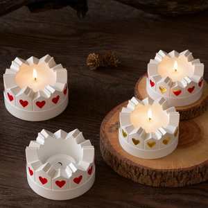 Set of four crown shaped candle holders with red heart patterns on rustic wood slices