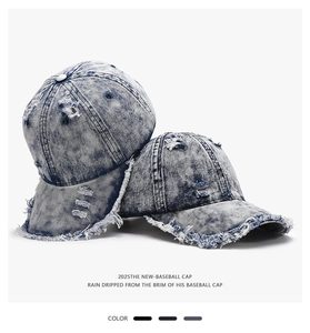 Detail of distressed blue denim baseball cap showing vintage ripped texture and frayed edges