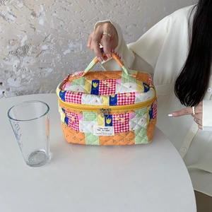 Close-up of a quilted cotton floral makeup bag with vintage patchwork and a thick handle