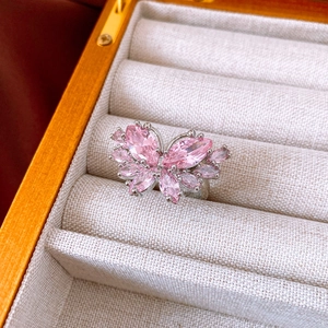 Macro view of pink marquise-cut zircon butterfly ring in a luxury wooden gift box