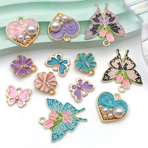 Detailed view of colorful enamel butterfly and heart pendants with pearls for DIY jewelry