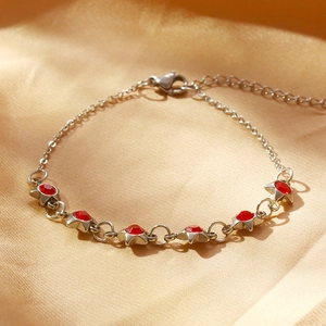 Détail d'un bracelet en argent avec zircons rouges en forme d'étoile sur soie dorée