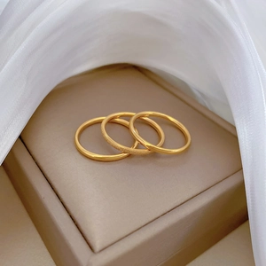 Three-piece minimalist gold titanium steel stackable ring set with polished and sandblasted finishes