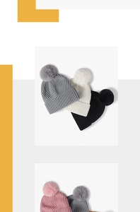 Détail du tricot et grands pompons en fourrure synthétique sur des bonnets d'hiver