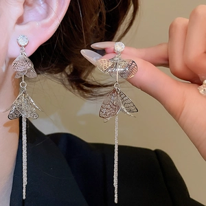 Vue détaillée des boucles d'oreilles à pompons argentés avec pétales évidés et zircons