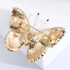 Detail view of the secure pin clasp structure on the gold-toned butterfly brooch