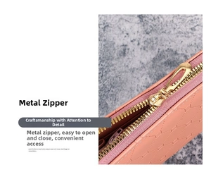 Detailaufnahme eines goldenen Metallreißverschlusses an einer rosa Ledergeldbörse