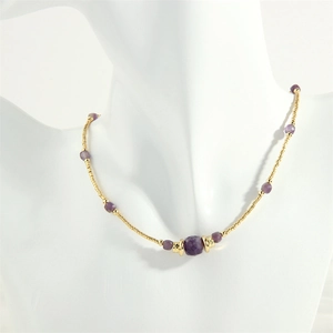 Close-up of lapis and amazonite beaded necklace with purple stone on mannequin