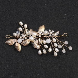 Close-up of bridal crystal hair vine with pearls and golden leaves on black background