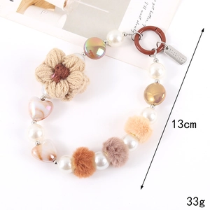 Detail showing crocheted sunflower charms and a Good Luck tag on a beaded keychain