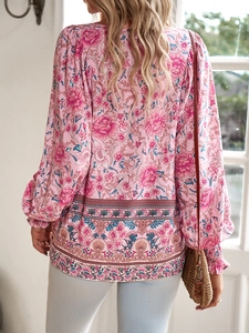 Detail view of pink boho floral shirt featuring long sleeves and ruffled hemline patterns