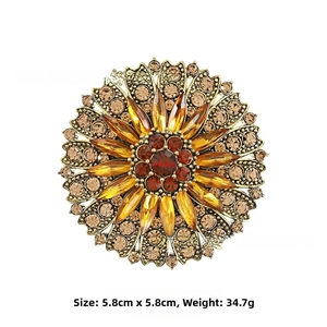 Detailed view of a vintage sunflower brooch with amber stones and red rhinestones