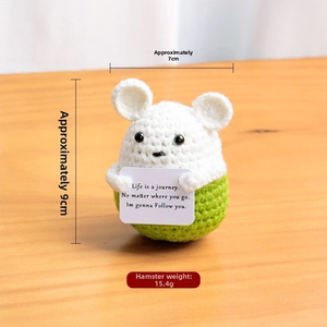 Macro detail of 9x7cm handmade crochet hamster doll with inspirational positive card