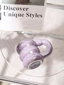 Detailed view of a purple pearlescent ceramic mug on a glass table with soft lighting