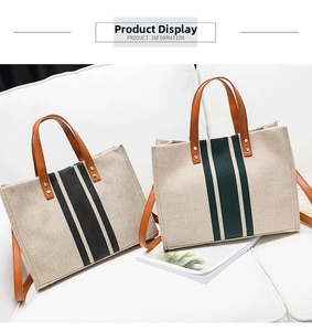 Close-up of canvas tote bags with leather handles and striped design on a white sofa