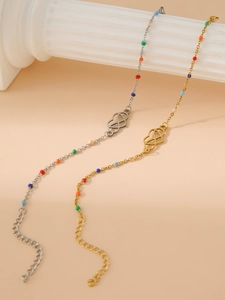 Detail view of 18k gold heart Mobius bracelet with colorful beads on stone stand