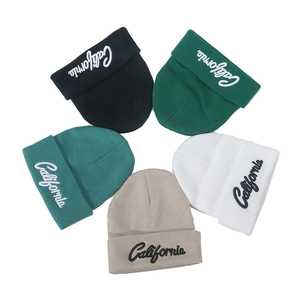 Detail of five-color knit beanies featuring embroidered California script and ribbed texture