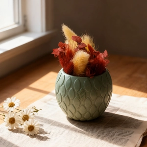 Detail of round dark green embossed resin flower pot mold with artistic scale texture
