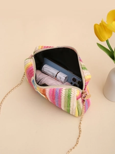 Rainbow straw crossbody bag with gold chain showing internal capacity and phone