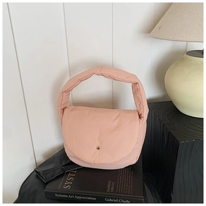 Detailed close-up of a pink quilted puffer hobo bag with a minimalist metal buckle fastener