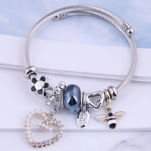 Silver twisted wire bracelet with bee and heart charms and black floral beads