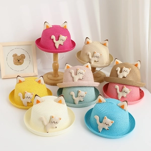 Close-up of children's straw hats featuring cute 3D cat ears and plush kitten decorations