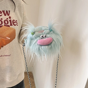 Detail of light blue fuzzy monster crossbody bag with pink lips and plaid strap on model