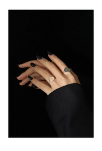 Detail view of two minimalist silver rings set with white and grey moonstones